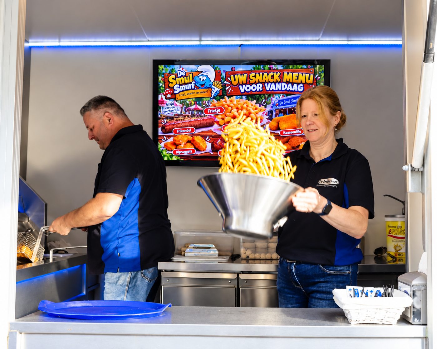 Dorien schudt een lading verse friet op in de frietwagen