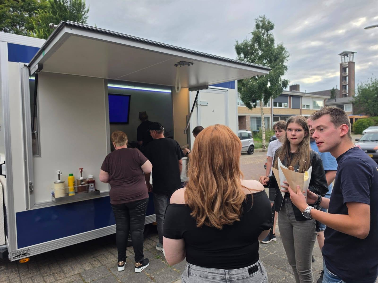 Klanten bestellen bij de frietwagen van De Smulsmurf